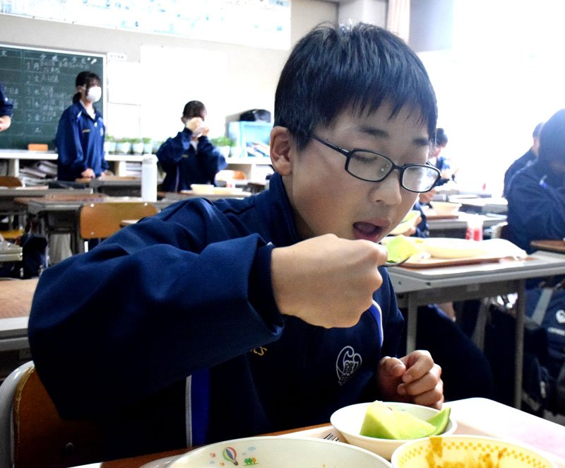 学校給食で提供されたメロンを頬張る中学生＝１日、銚子市