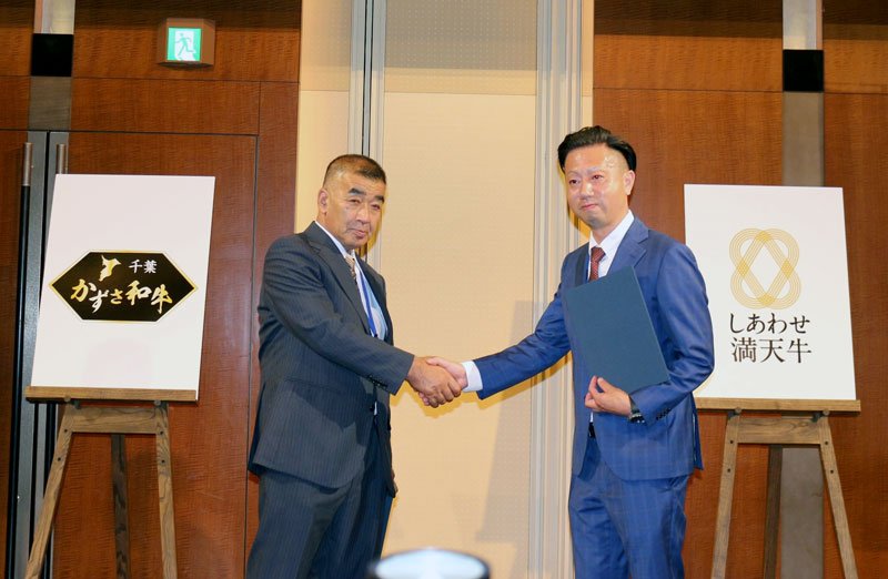 調印式で握手する麻生会長（左）と岩渕会長＝都内
