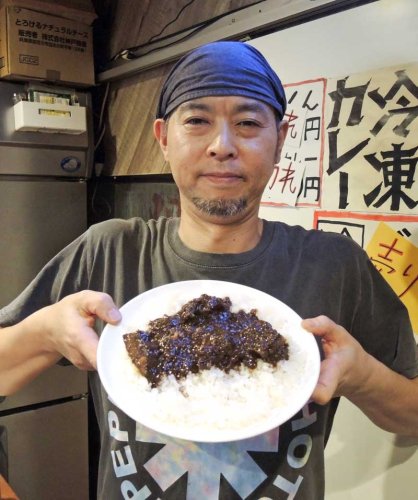 タマネギをとことん炒めて調理した「シャヒジャルカレー」を手にする浅野さん＝１０日、柏市