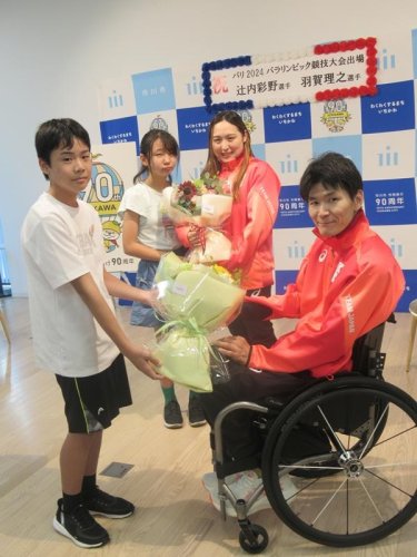 地元の小学生から花束を受け取り笑顔の羽賀（手前右）、辻内（奥右）両選手＝市川市役所
