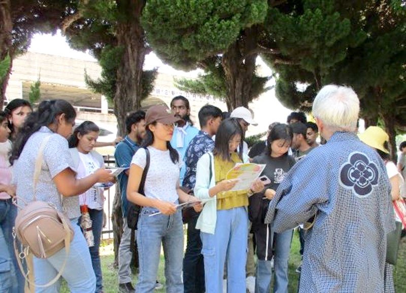 祭りに関する説明を聞く留学生ら（習志野署提供）
