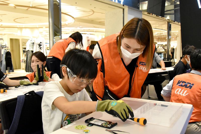 真剣な顔つきでスマートフォンを分解する児童＝千葉市中央区