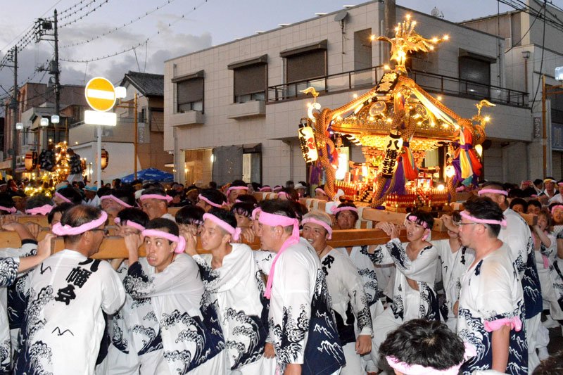 遠見岬神社の石段下の交差点で豊浜３区のみこしが集結し互いに担いでみせた＝１４日夜、勝浦市