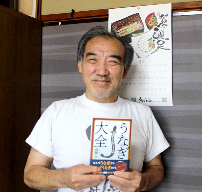 「読めばもっとおいしくなる　うなぎ大全」を手にする高城さん