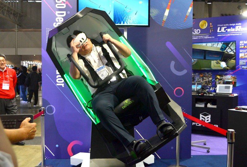 ＶＲと動く座席を組み合わせたシミュレーターを体験する来場者＝２６日、千葉市美浜区の幕張メッセ
