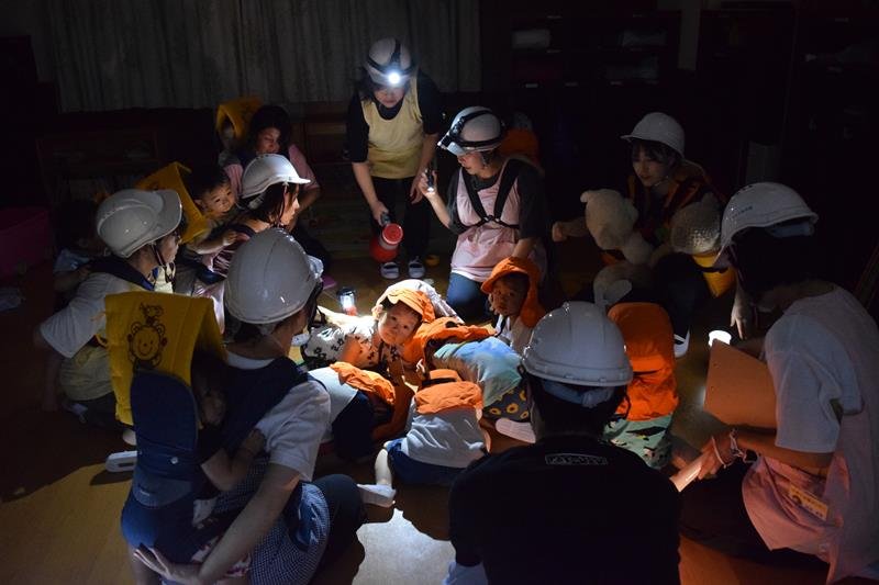保育士の指示に従って部屋の中央に避難する訓練をした保育園児ら＝８月２２日、松戸市