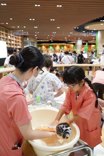 赤ちゃんのお世話体験で人形の体を丁寧に洗う女児＝旭市

