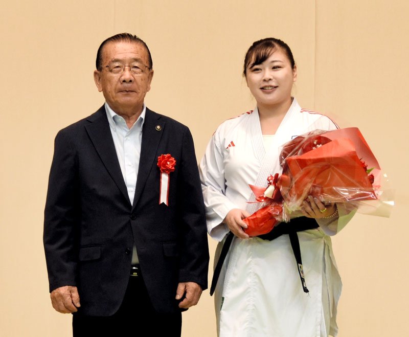 引退セレモニーで北村市長（左）から花束を受け取った植草さん＝６日、八街市