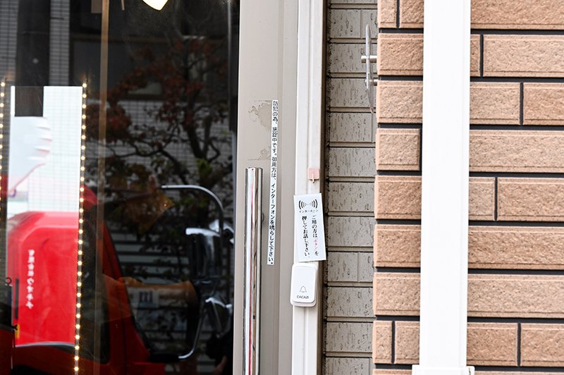 強盗予備事件で、男らが開けようとしたという店のドア。「防犯の為、施錠中です」と書いたシールが貼られていた＝２４日午前１０時４５分ごろ、船橋市宮本