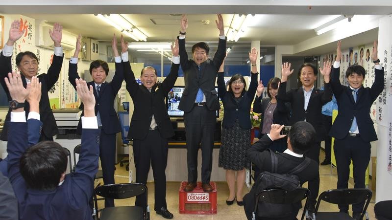 当選を決め、支援者と万歳三唱する立憲民主党の奥野氏（中央）＝２７日、四街道市
