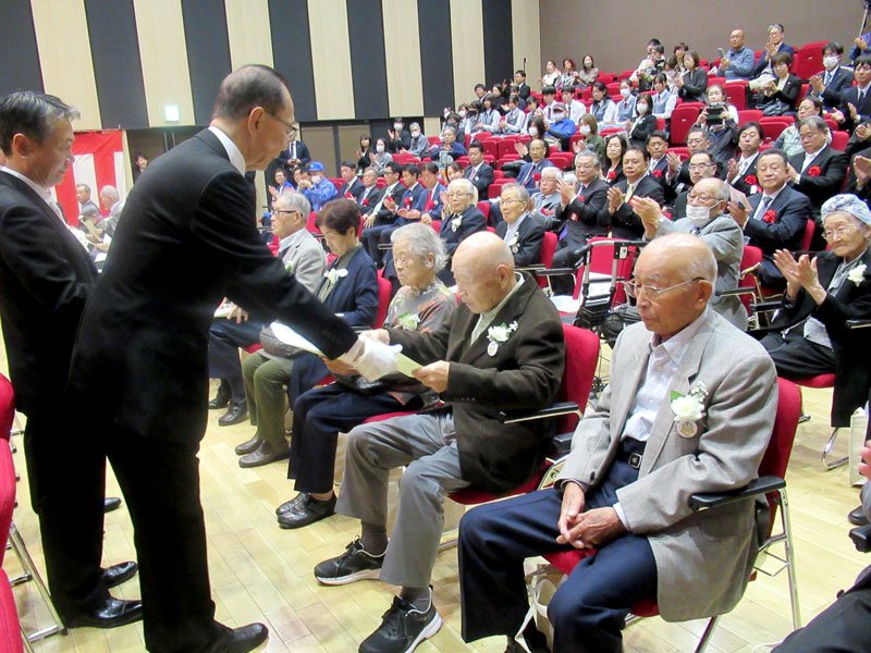 勝山教育長（左）から卒業証書を受け取る出席書＝市川市