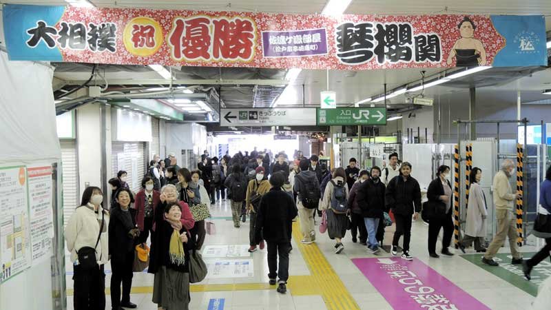 琴桜の優勝を祝う横断幕に市民らが見入った＝２５日、松戸駅