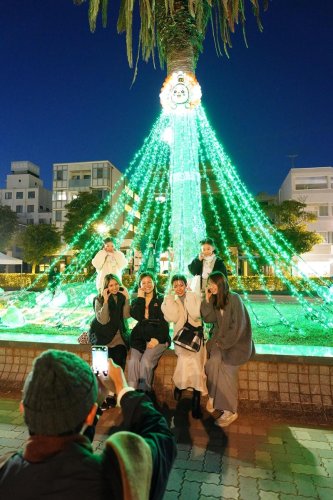 光輝くイルミと一緒に写真撮影する市民ら＝銚子市
