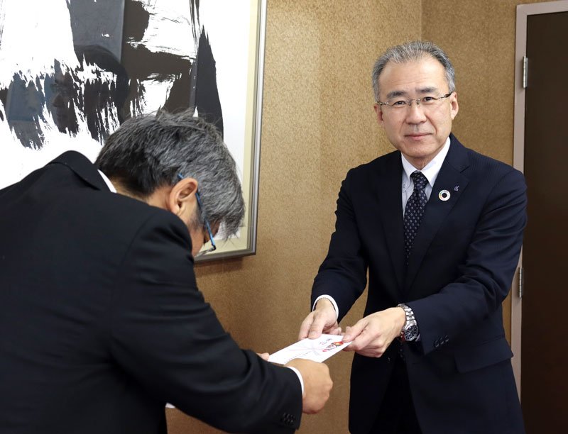寄付金を託す有賀推進本部長（右）
