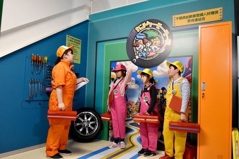 内覧会で、自動車整備士の仕事の説明などを聞く参加者ら＝１６日、千葉市美浜区