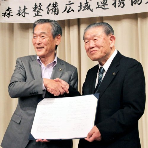 協定締結式で握手する松戸市の本郷谷市長（左）と鴨川市の長谷川市長＝千葉県庁