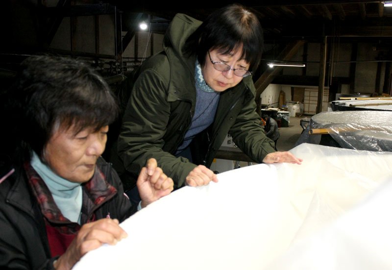 仕込み中の酒の状態を確認する宮崎さん（右）と秋場社長＝一宮町の稲花酒造