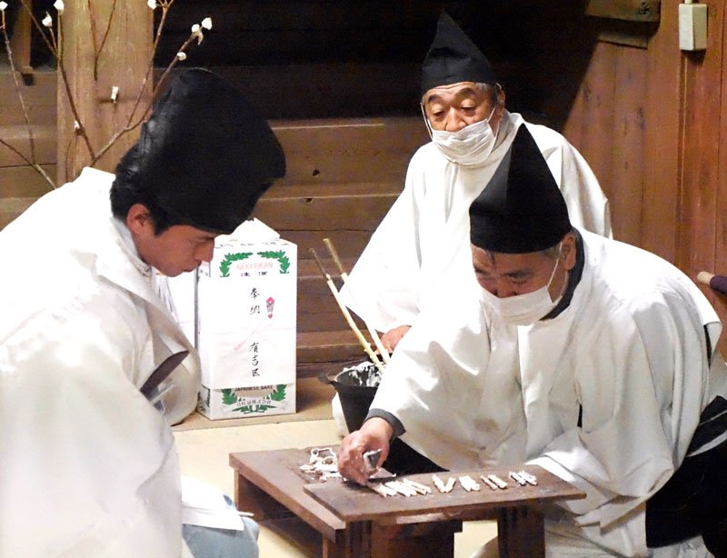 葦を切り裂き、詰まったかゆの量を確認する神職＝１５日未明、袖ケ浦市