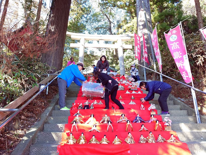 高瀧神社の石段にひな人形を並べる地元の人たち＝１１日、市原市
