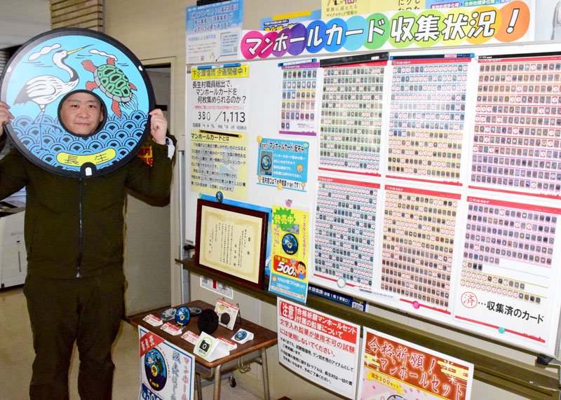 マンホールカードの収集状況を紹介するボード。収集済には「済」のシールが貼られている。長生村のご当地マンホールふたの顔はめパネルも作った＝同村役場