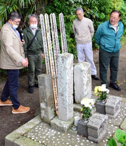 白子町指定文化財の「無縁塚津波精霊様」を見つめる参加者。約３６０人の津波犠牲者を埋葬した場所だと伝わる