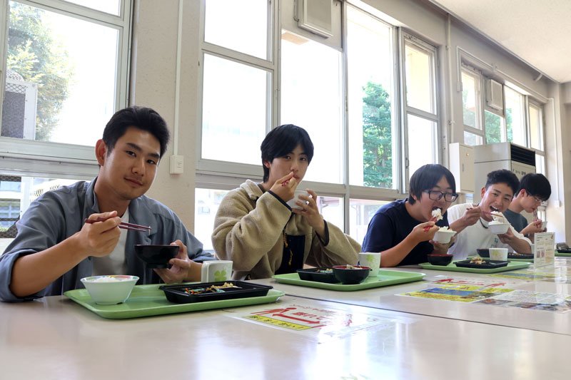 学食で提供された「めだか米」を頬張る学生たち＝東金市