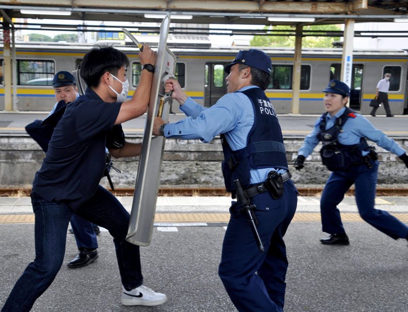 刃物を持って暴れる不審者役を制圧する市原署員＝２６日、市原市のＪＲ姉ケ崎駅