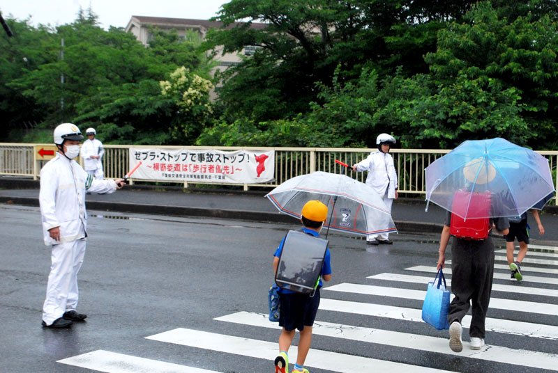 登校中の児童を見守る警察官＝２６日午前７時２０分ごろ、佐倉市大崎台４の寺崎小学校付近