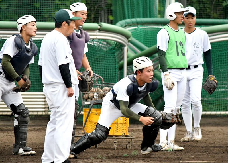 活発に声をかけ合いながら練習する専大松戸の捕手陣。左手前は持丸監督＝松戸市
