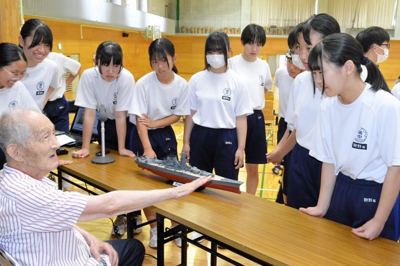 艦船の鉄片が残る右腕を見せながら話す早川さん＝勝浦市
