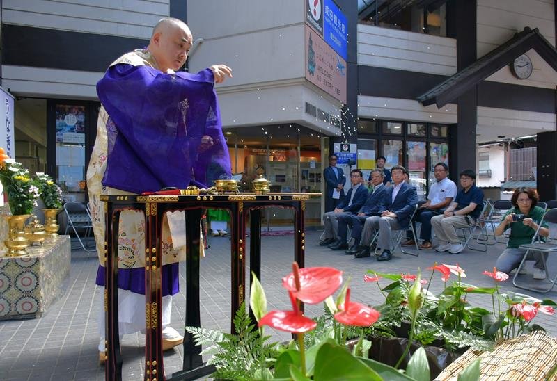 うなぎ供養・放生会を行う池を清める成田山新勝寺の僧侶＝１８日、成田市
