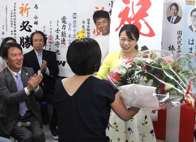 初当選を決め、花束を受け取る小林さやか氏（右）＝２０日、千葉市中央区
