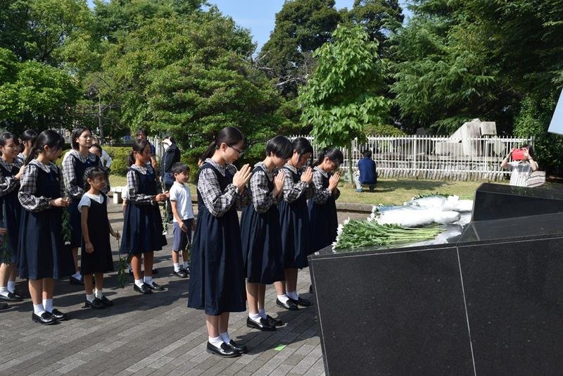 平和祈念碑に献花し平和を祈る八千代少年少女合唱団のメンバーら＝６日、八千代市
