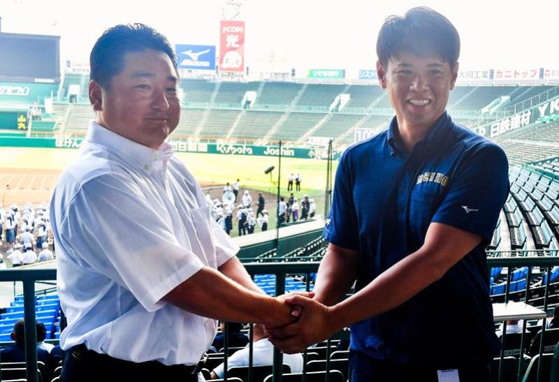 握手する市船橋の海上監督（左）と明豊の川崎監督＝甲子園