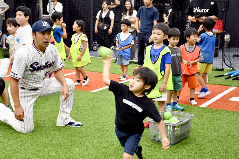 小森さん（左）の指導を受け、ボール投げに挑戦する参加者＝鎌ケ谷市