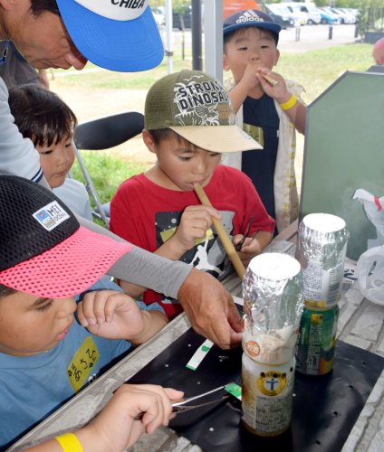 空き缶を使ってご飯を炊く子どもたち＝２３日、睦沢町