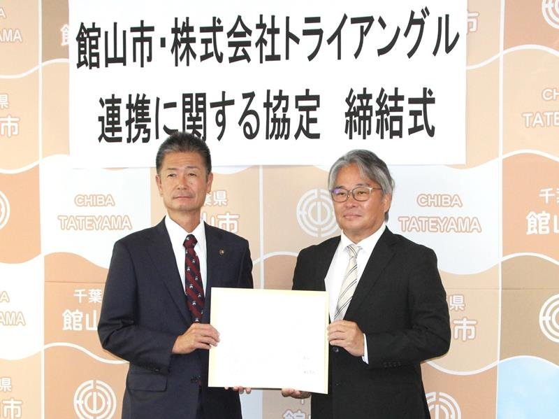 協定書を持つ森市長（左）と鈴木社長＝館山市役所
