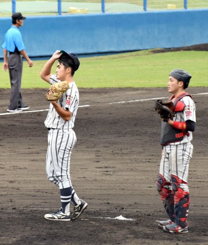 武道大－城国大　９回表無死一、二塁のピンチで汗をぬぐう武道大・山口塁（左）＝長生の森