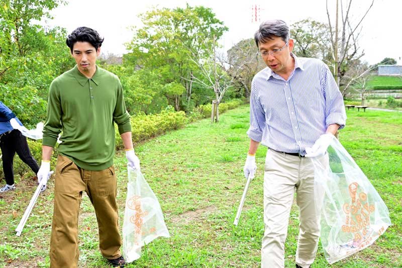 ごみ拾いを行う賀来さん（左）と山田社長＝１９日、市原市