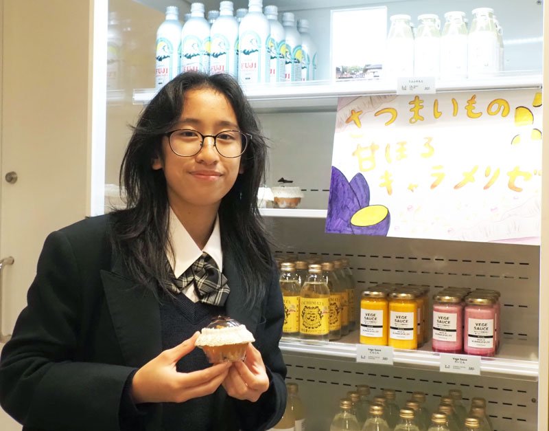 自分たちで栽培した農産物を加工して作った商品を手に店内で販売に立つ高校生＝２４日、木更津市