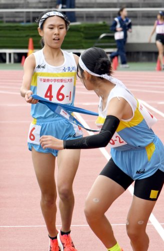 女子１区で区間賞の走りを見せ、２区の平田彩夏にたすきを渡す小見川の向後（左）
