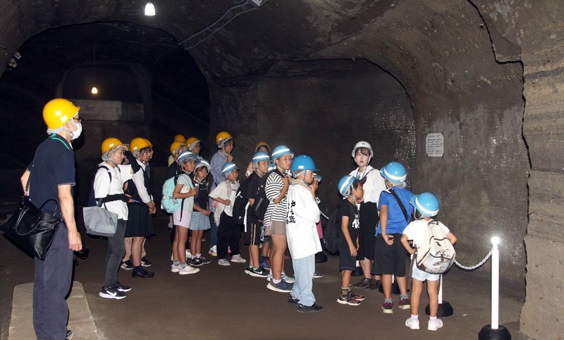 赤山地下壕跡を見学する神余小学校の児童と保護者ら＝８月、館山市