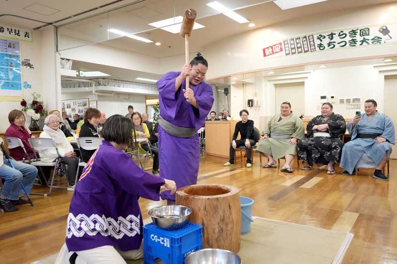 施設利用者らの前で餅をつく大栄翔関（中央）＝旭市