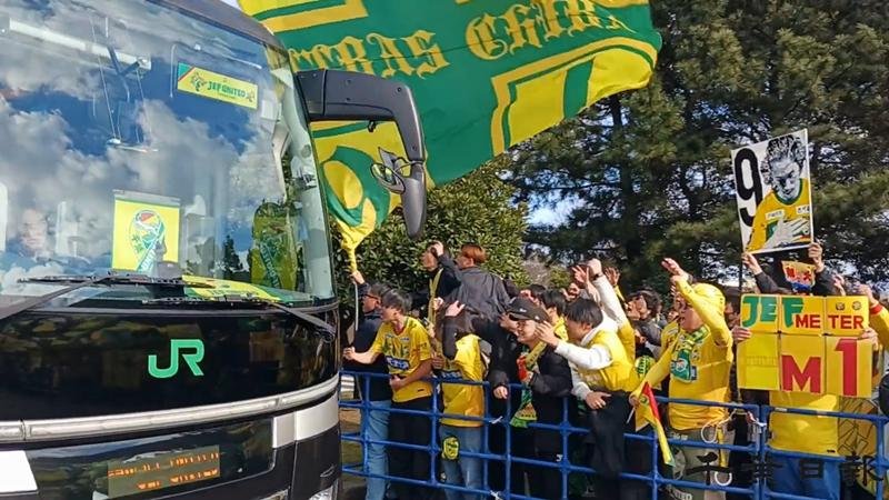 試合会場のフクダ電子アリーナに入るジェフの選手たちを乗せたバスを鼓舞して出迎えるサポーター＝１３日、千葉市中央区