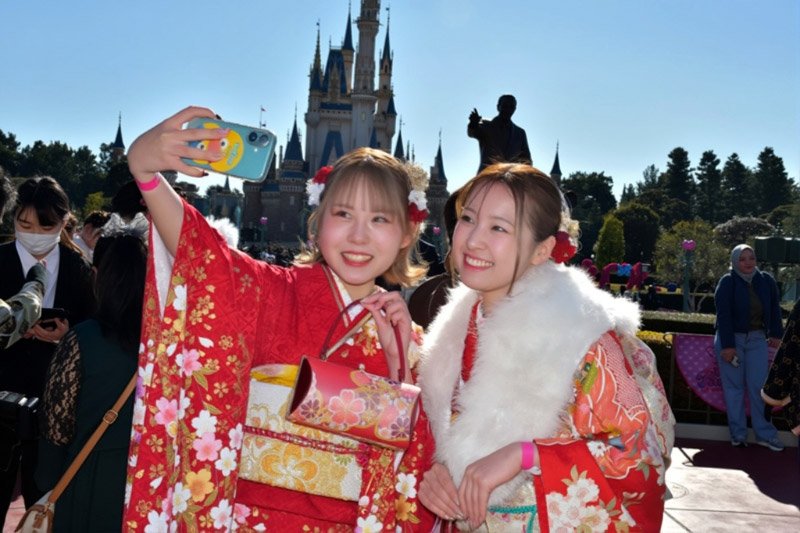 仲良く記念撮影する「新２０歳」の若者＝１２日、浦安市の東京ディズニーランド