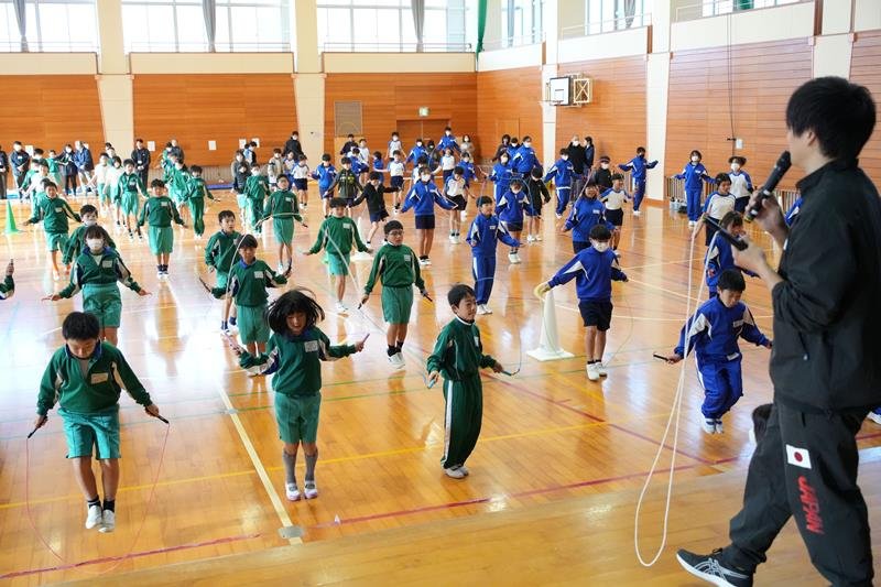 黒野さん（右）の指導で一斉に縄跳びをする小学生たち＝旭市立古城小体育館

