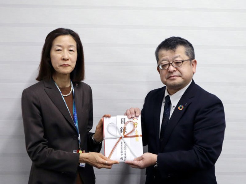 井上環境生活部長に目録を手渡す京葉銀の喜多見法人営業部長＝千葉県庁