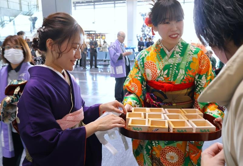 成田空港でお屠蘇を振る舞う空港スタッフら＝１日、成田市
