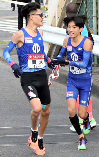 ２区・吉岡大翔にたすきを手渡す順大の１区・池間凛斗（左）＝２日、神奈川県横浜市の鶴見中継所