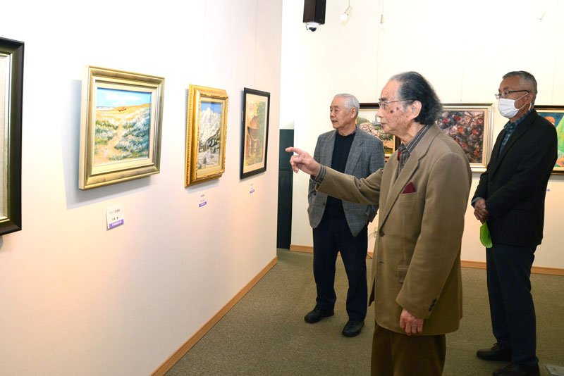 作品を前に解説する前嶋会長（中央）＝８日、千葉市中央区